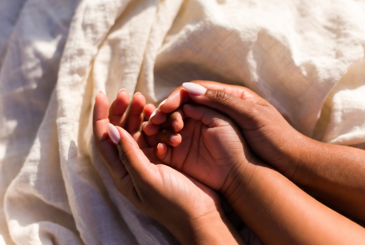 A mother holding her child's hands